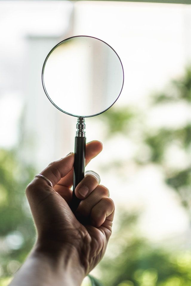 Hand holding magnifying glass